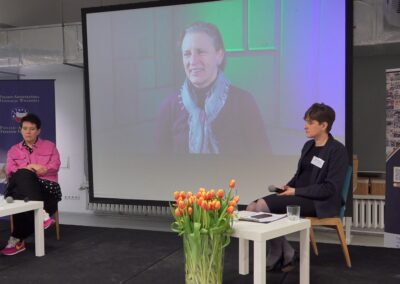 Na scenie siedząca prelegentka, dwoje gości oraz pomiędzy nimi ekran z nagraniem wywiadu z panią Lidią Kuczmierowską z Fundacji Akademia Organizacji Obywatelskich.