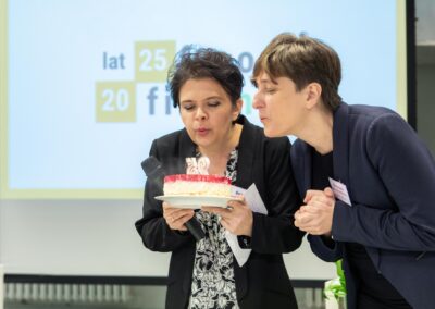 Pani Beata Juraszek-Kopacz, prezes i pani Katarzyna Adamska-Dutkiewicz, wiceprezes FRSO zdmuchują wspólnie świeczkę z symbolem "25" z tortu okolicznościowego.